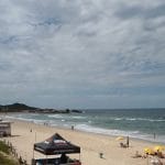 Praia mole em dia de sol e campeonato de surf